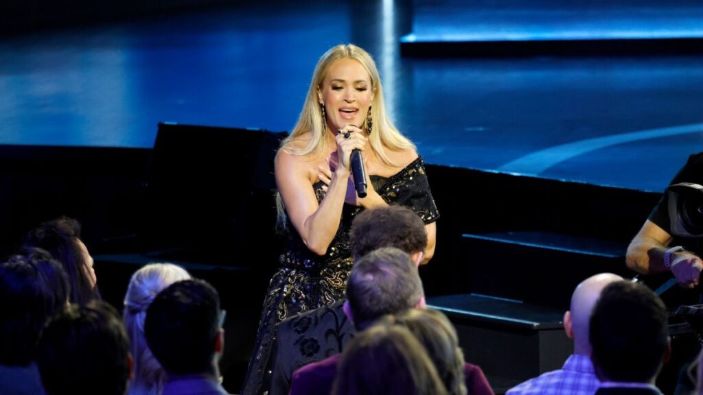 Carrie Underwood took the stage with no dancers, no effects, just a spotlight and a single song that changed everything. She sang Randy Travis’ “I Told You So” not just as a cover, but as a sacred tribute to the man who inspired her entire career. Her voice soared, Randy sat silent, unable to speak since his stroke but clearly overcoming it