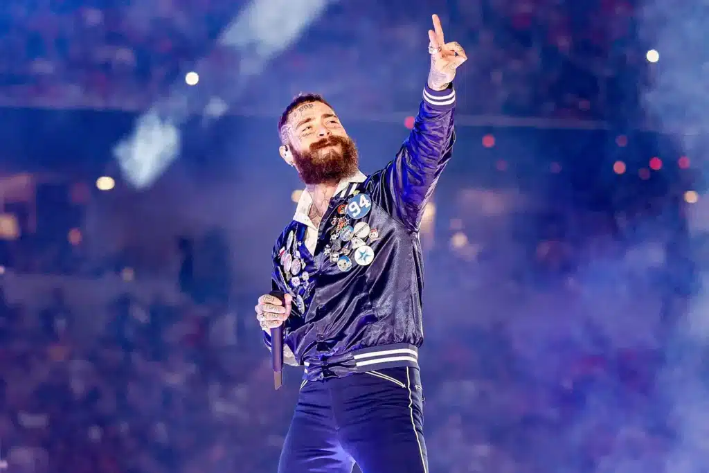 “THIS ONE’S FOR YOU, 94… WE LOVE YOU, WE MISS YOU.” Post Malone’s Voice Trembled Across At&t Stadium, And For A Heartbeat, The Roar Of Thanksgiving Football Faded Into Silence. The Texas-born Superstar, Longtime Cowboys Fan, And Global Icon Had Paused Mid-game To Honor Marshawn Kneeland, The 24-year-old Player Lost Far Too Soon, And In That Moment, Every Fan — From The Stands To The Broadcast Screens — Felt The Weight Of Grief And Love Collide. Malone’s Tribute Wasn’t Flashy Or Rehearsed; It Was Raw, Intimate, And Devastatingly Human. Eyes Glistened As He Whispered, “You’re Never Gone… We Carry You With Us,” The Words Hanging Over The Stadium Like A Solemn Prayer. For A Few Breathtaking Minutes, Music, Memory, And Mourning Intertwined, Turning The Arena Into A Cathedral Of Remembrance, Leaving Thousands Trembling, Tearful, And Forever Changed.