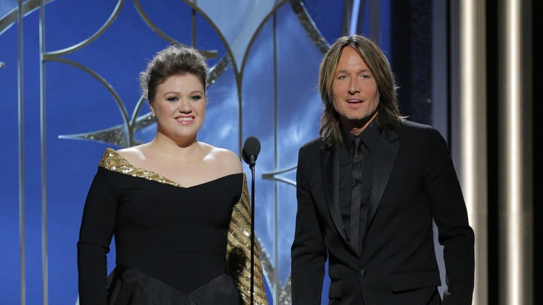 “THE ENTIRE AUDITORIUM FREEZED FOR 12 SECONDS — NO FIREWORKS, NO SHOUTING, JUST TWO VOICES THAT SILENTLY MOVED OVER 3 MILLION PEOPLE” No flashing lights, no grand stage, just Keith Urban and Kelly Clarkson standing less than an arm’s length apart — and the world seemed to stop. When the first note began, over 15,000 audience members held their breath, and social media exploded with over 3 million views in just a few hours. No one applauded, no one shouted — because the moment was too fragile to break. The two voices blended together slowly, so close it felt like they were whispering into the hearts of the listeners, transforming the entire auditorium into a rare, sacred silence. Viewers said they “forgot they were at a concert,” with tears falling before they even realized it. This wasn’t just a duet—it was a living moment, where music directly touched memories, making this Christmas unforgettable.