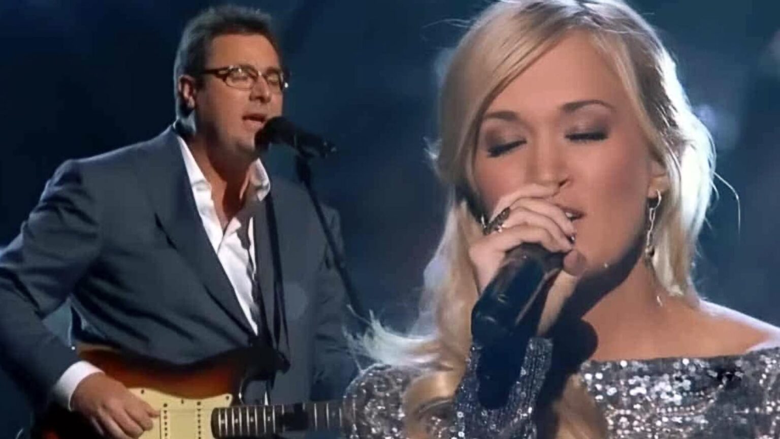 “THEY DIDN’T RAISE THEIR VOICES — THEY SHATTERED THE ROOM WITH SILENCE.” When Carrie Underwood and Vince Gill stepped into He Stopped Loving Her Today, the atmosphere didn’t just change — it froze. This wasn’t a show built for applause or power, but a sacred exchange where every pause carried more weight than any high note. Carrie chose stillness over spectacle, letting grief breathe between the lines, while Vince stood beside her like a quiet anchor, guiding without ever demanding attention. The room held its breath as sorrow softened into reverence, and time seemed to slow with every word. It wasn’t loud, it wasn’t dramatic — it was devastating in the most gentle way imaginable.